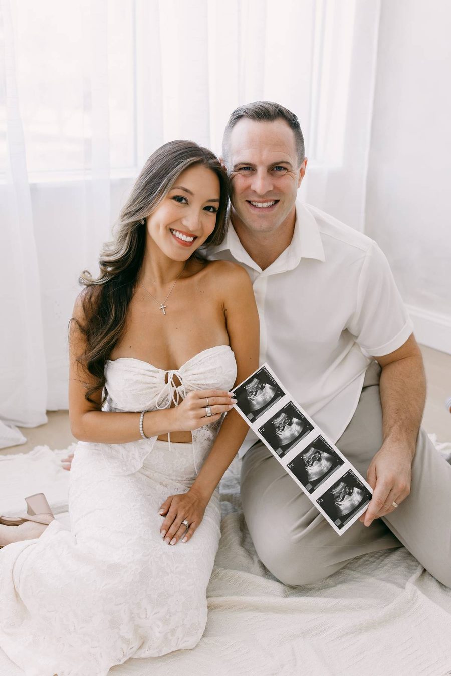 Linda and Collin seated together in soft daylight, announcing their pregnancy