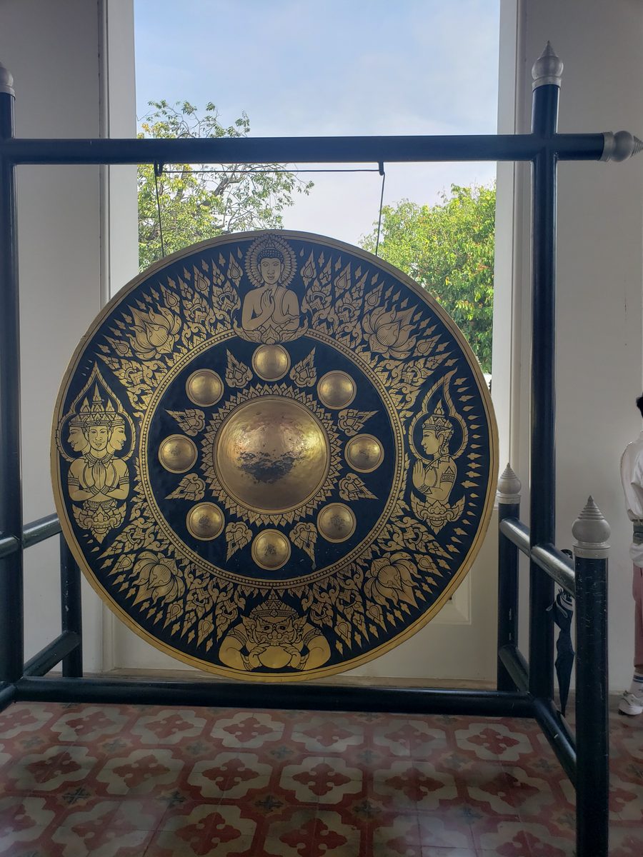 A large black and gold temple gong in a Bangkok wat