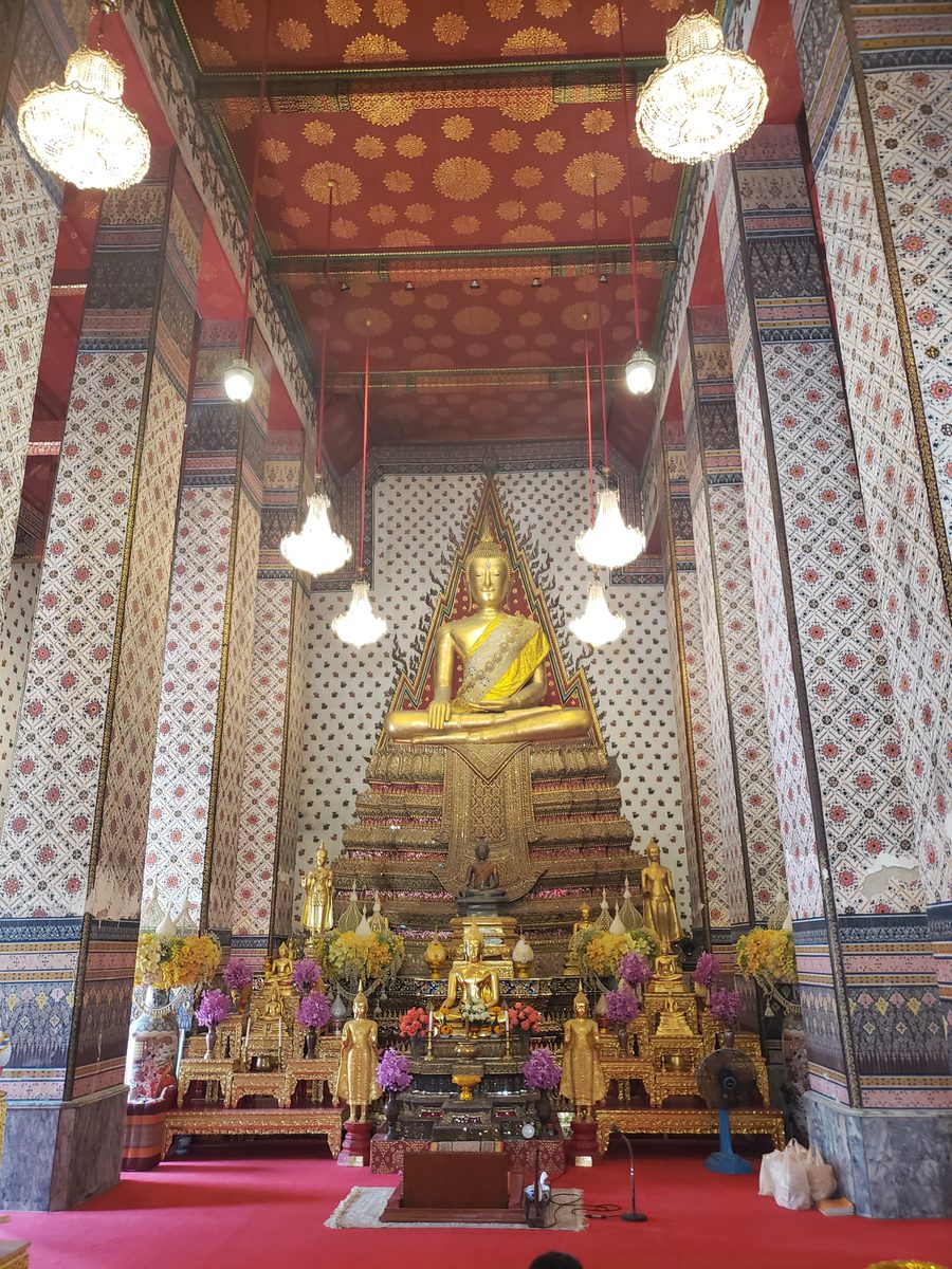 Golden Buddha on an ornate altar in the ordination hall at Wat Arun