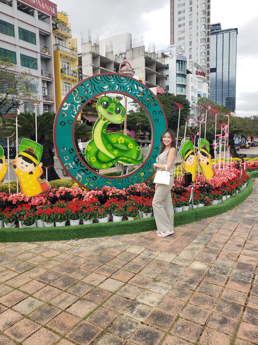 Linda standing beside a Tet snake display on a Da Nang street